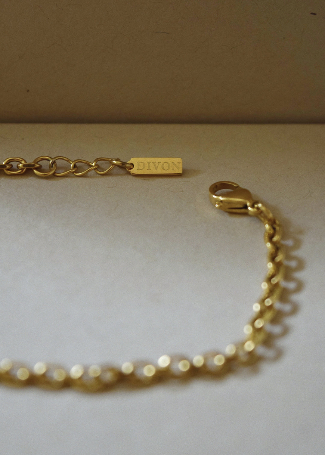 DIVON 3mm gold anchor bracelet – classic chain style shot with warm natural shadows