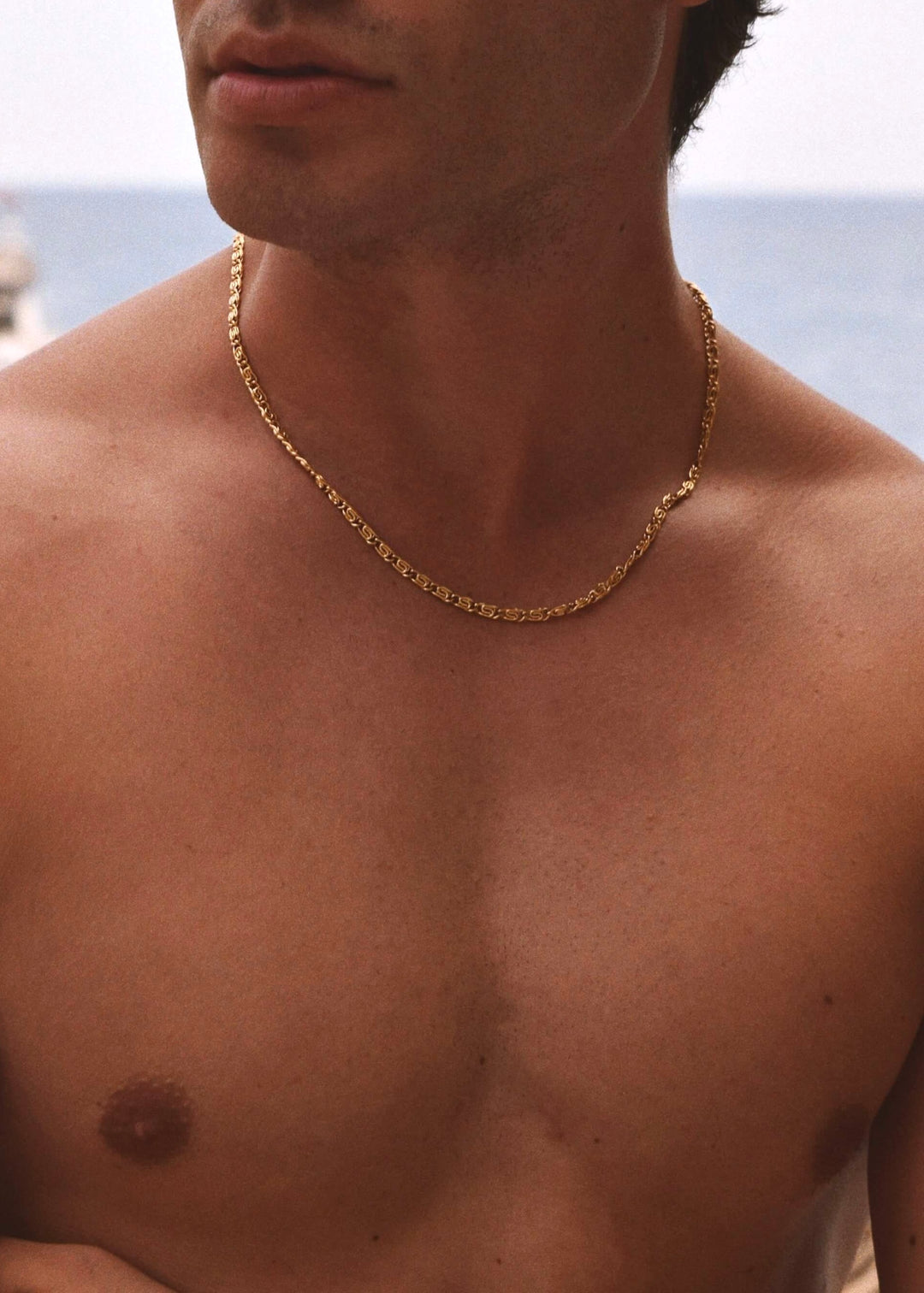 Unisex 4mm Snail Chain by DIVON – gold-plated necklace styled on male model for bold simplicity on the beach 