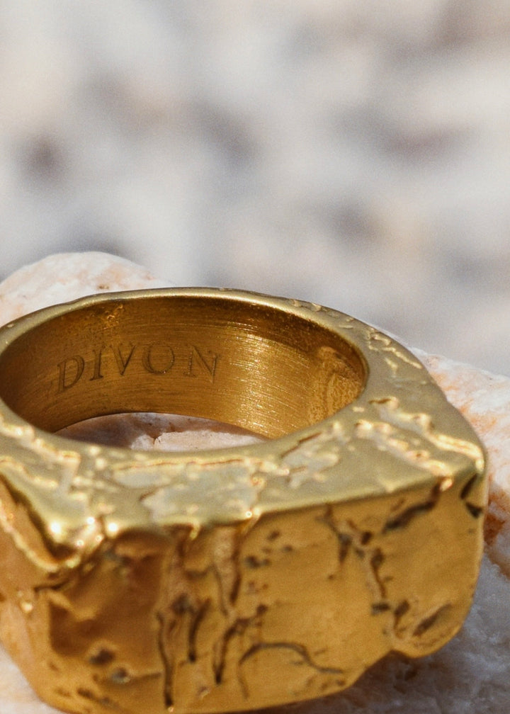 A gold ring with the word DIVON on it.